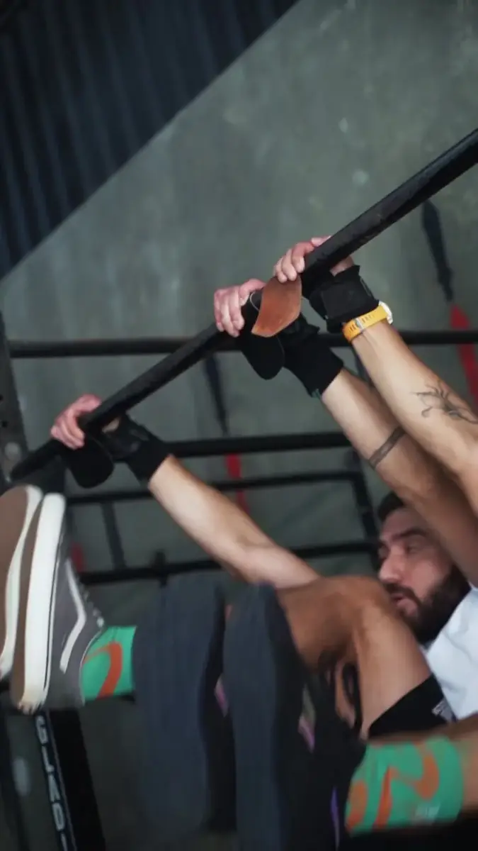 Atleta de camiseta laranja levantando a barra