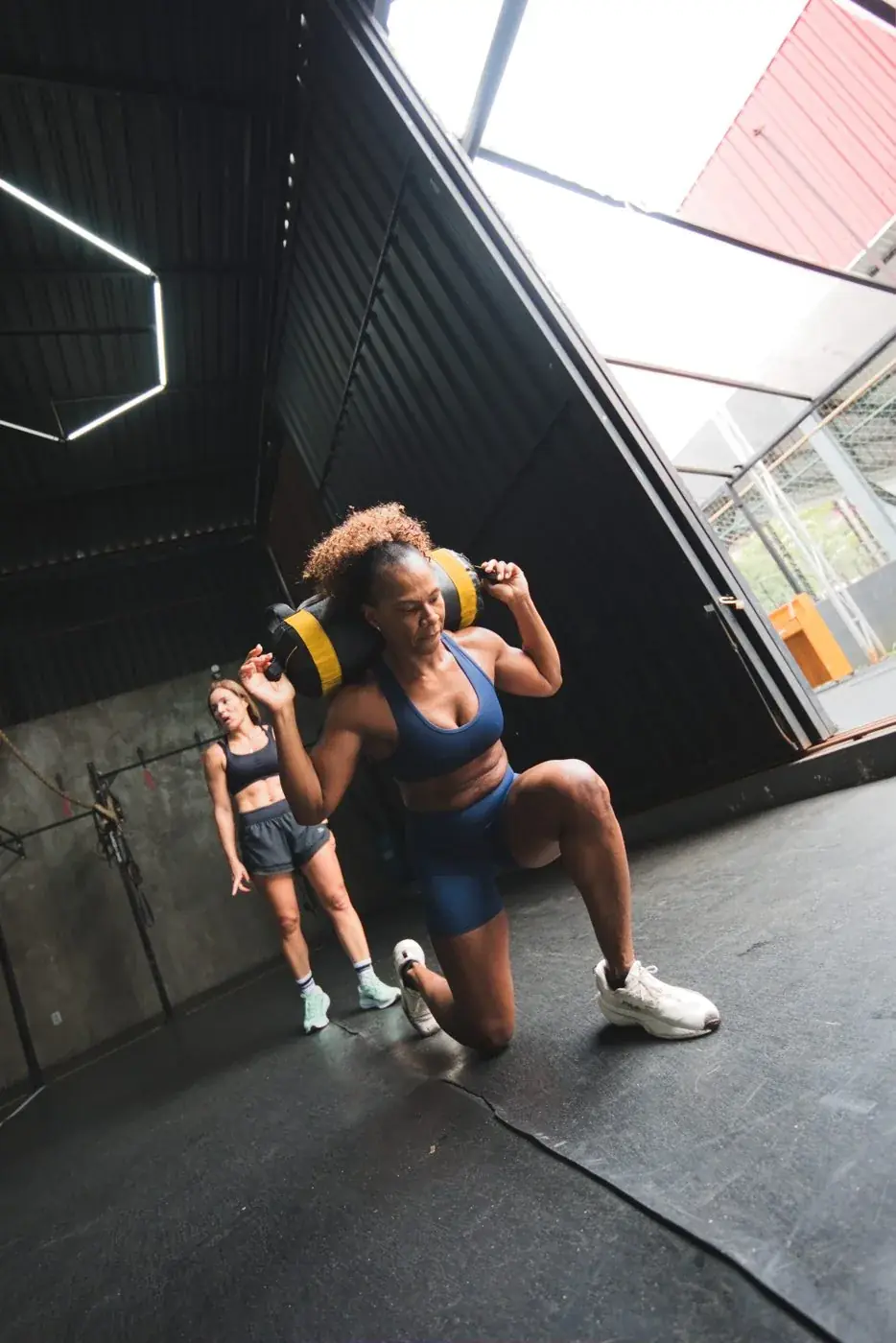 Atleta em avanço com sandbag