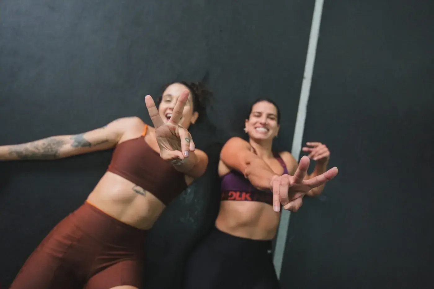 Duas atletas deitadas no chão comemorando depois do simulado