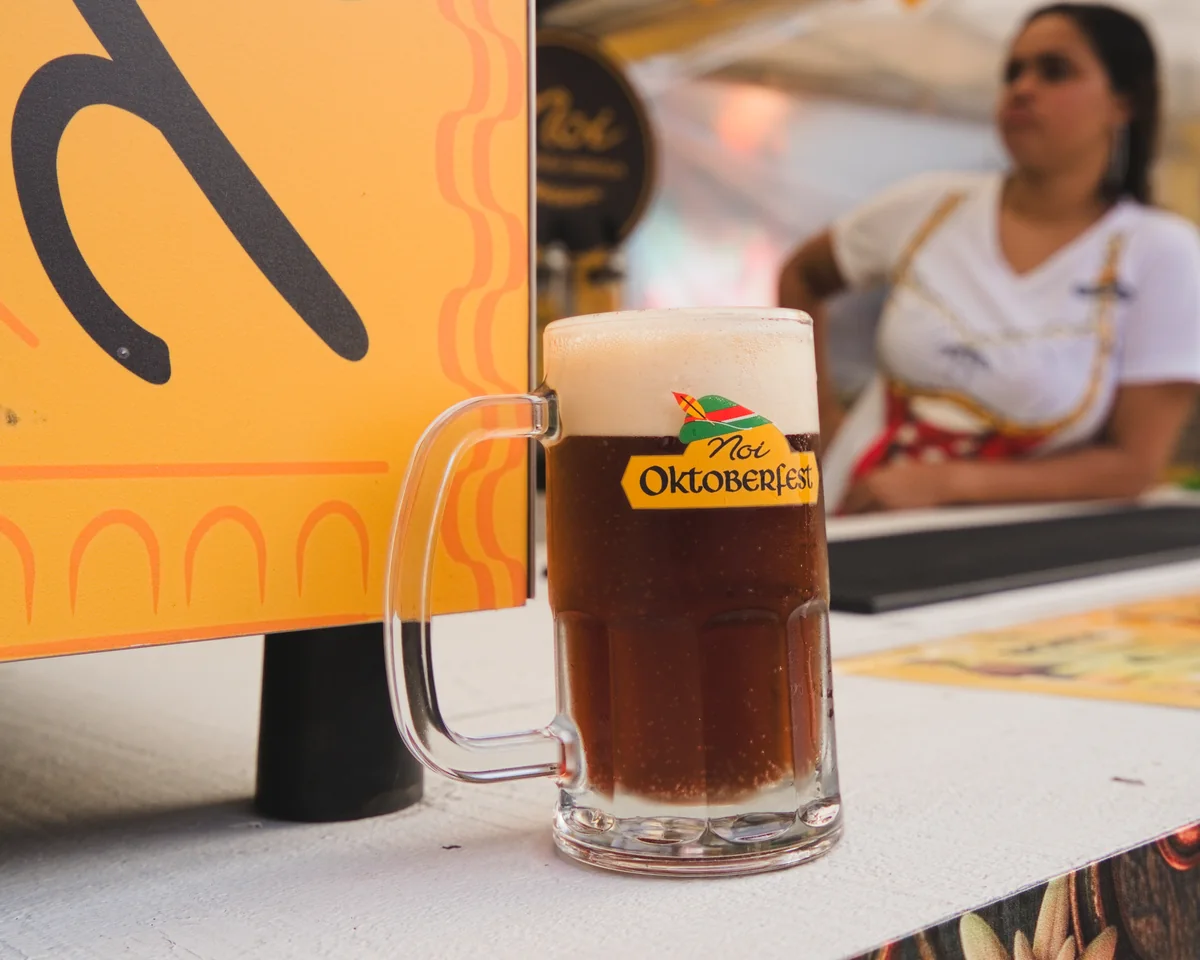 Caneca de chopp escuro com o logo da Oktoberfest no balcão da Noi